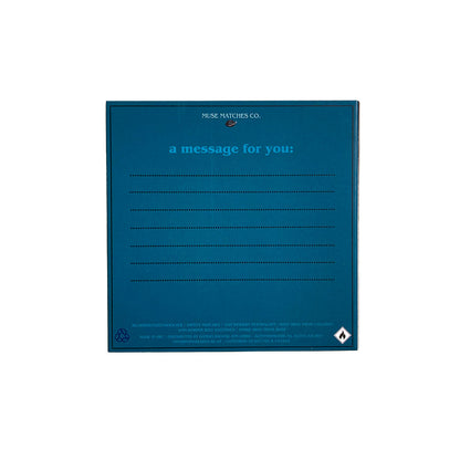 • Blaue Rückseite einer Muse Matches Co. Streichholzverpackung mit Linien für Notizen und Sicherheits- und Entsorgungshinweisen am unteren Rand.
