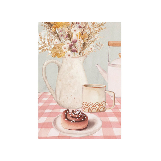 Aquarell-Stillleben mit einer Zimtschnecke auf einem Teller, einer Tasse Kaffee und Trockenblumen in einer weißen Vase auf rot-weiß karierter Tischdecke.