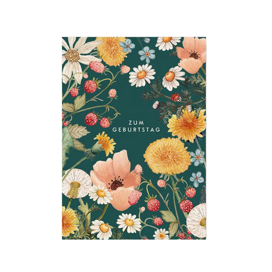 Eine botanische Aquarell-Illustration auf einem dunkelgrünen Hintergrund. Die Karte ist mit einem dichten Rahmen aus naturgetreuen Wildblumen und Früchten gestaltet, darunter leuchtend gelber Löwenzahn, weiße Gänseblümchen, zartrosa Mohnblüten und kleine rote Walderdbeeren an ihren Ranken. In der Mitte der Karte steht in schlichten, weißen Großbuchstaben der Schriftzug „ZUM GEBURTSTAG“. Ein kleiner Marienkäfer krabbelt dezent auf einem der Blätter.