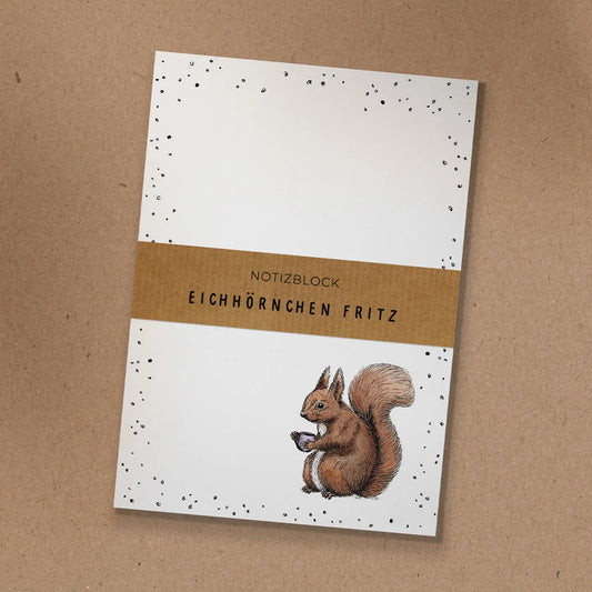 Notizblock mit Kraftpapier-Banderole und handgezeichneter Illustration von Eichhörnchen Fritz mit einer Kaffeetasse.