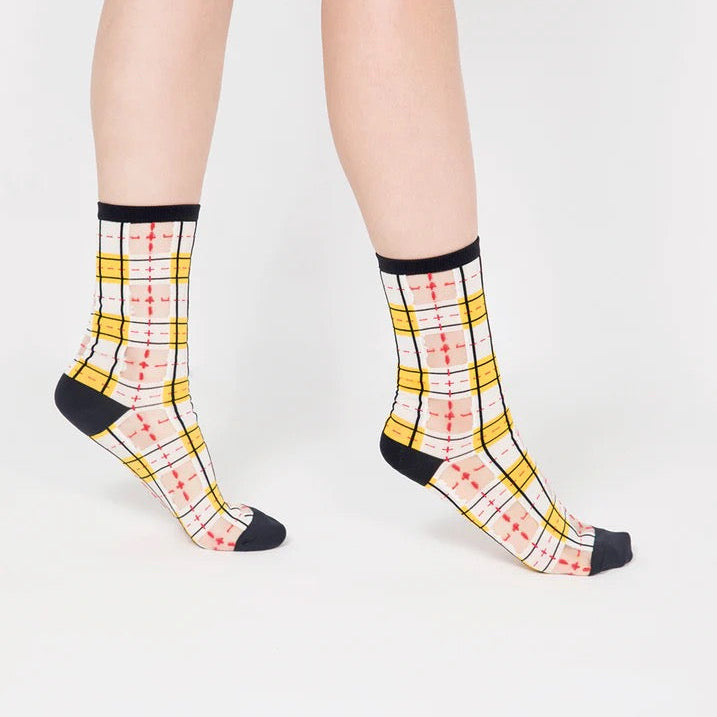 Nahaufnahme der PAPERSELF Tartan Socken zeigt das feine, transparente Gewebe und die präzisen, handgeschnittenen Details des Karomusters.