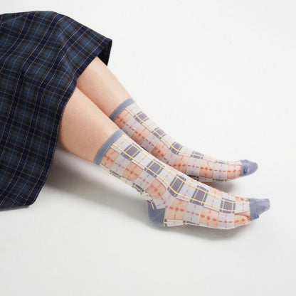 Modische Kombination: PAPERSELF Sheer Socks im Tartan-Design getragen für einen modernen Streetstyle-Look.