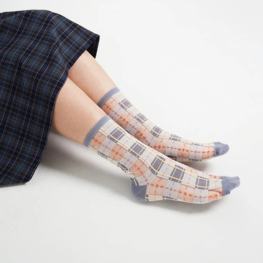 Modische Kombination: PAPERSELF Sheer Socks im Tartan-Design getragen für einen modernen Streetstyle-Look.