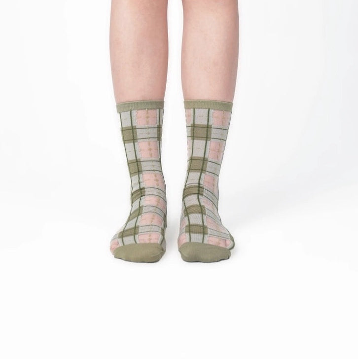 Nahaufnahme der PAPERSELF Tartan Socken zeigt das feine, transparente Gewebe und die präzisen, handgeschnittenen Details des Karomusters.