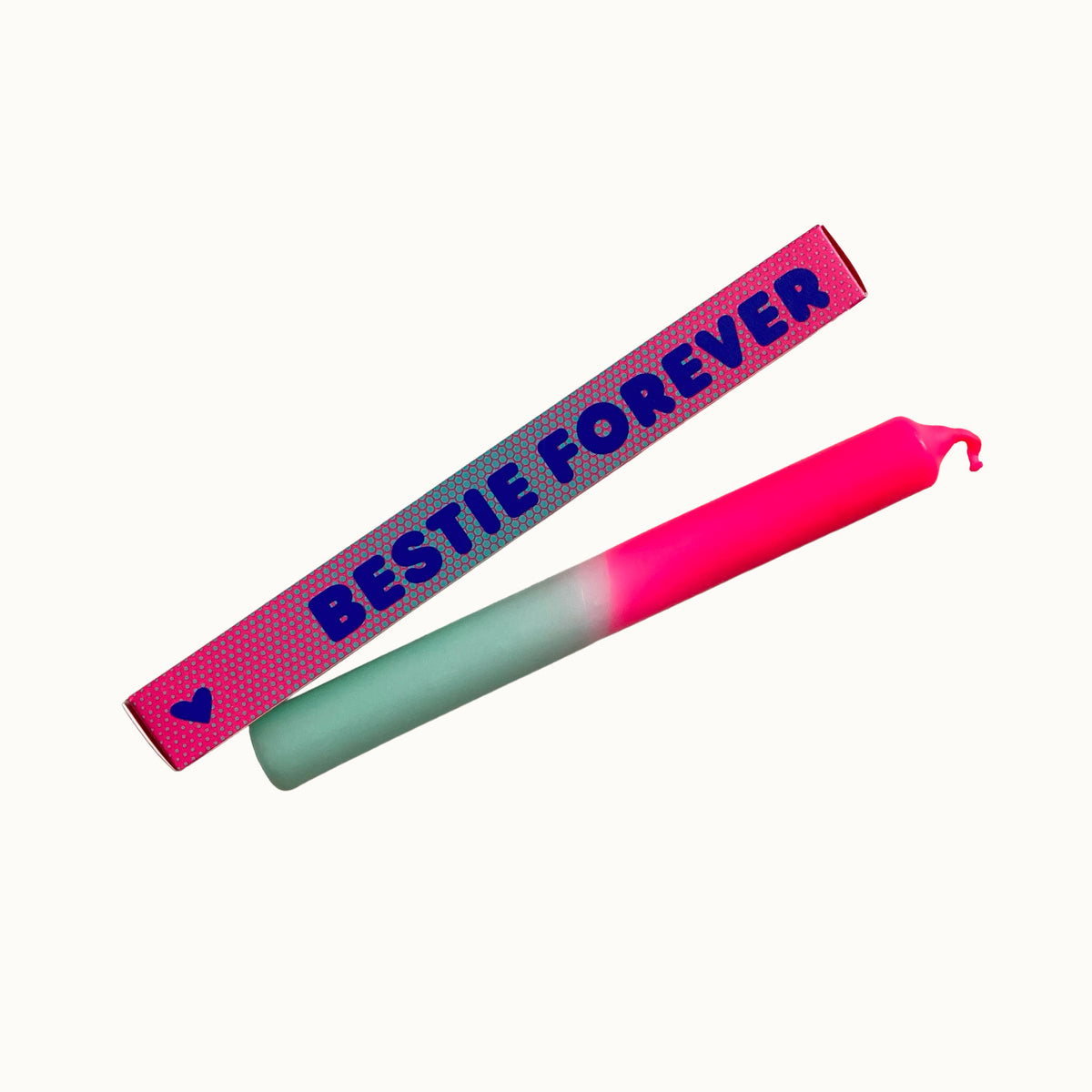 Eine farbenfrohe Dip-Dye-Stabkerze von Pink Stories mit Neon-Pink und Mintgrün, daneben die pinke Geschenkbox mit Herz-Detail und der Aufschrift „BESTIE FOREVER“.