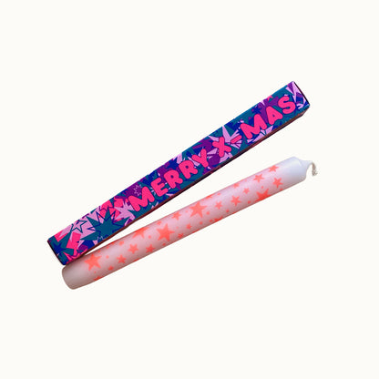 Freigestellte Pink Stories Dip-Dye Stabkerze in Weiß und neon pinken  Sternen mit MERRY X-MAS Verpackung auf weißem Hintergrund