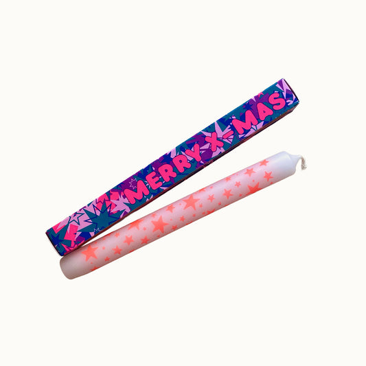 Freigestellte Pink Stories Dip-Dye Stabkerze in Weiß und neon pinken  Sternen mit MERRY X-MAS Verpackung auf weißem Hintergrund