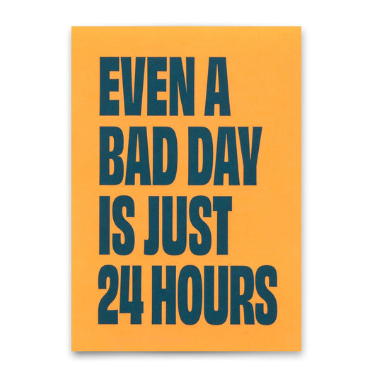 Diese Postkarte verfügt über eine kräftige Typografie auf einem leuchtend orangefarbenen Hintergrund mit der motivierenden Botschaft "EVEN A BAD DAY IS JUST 24 HOURS" in großen, dunklen blaugrünen oder marineblauen Buchstaben.