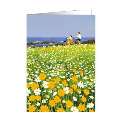 Künstlerische Illustration einer Grußkarte: Ein Mann und eine Frau fahren auf Fahrrädern durch ein dichtes Feld mit gelben und weißen Gänseblümchen an einer Küste. Im Hintergrund ist das blaue Meer unter einem klaren Himmel zu sehen.