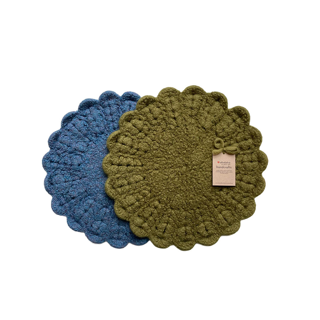 Ein Set aus zwei runden, handgearbeiteten Stuhlauflagen aus echter Wolle in kräftigem Blau und natürlichem Olivgrün.