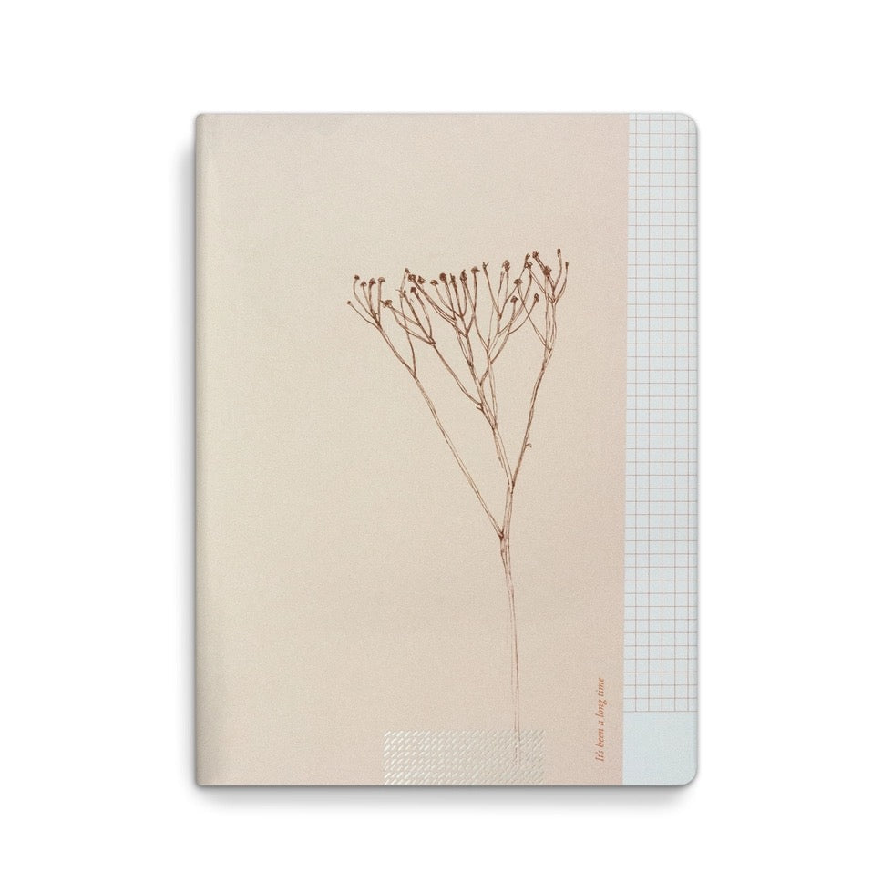 Frontansicht des Tinne Mia Notizhefts in Puder-Beige mit minimalistischer Pflanzenzeichnung, Karo-Akzent am Rand und silbernem Foliendetail.