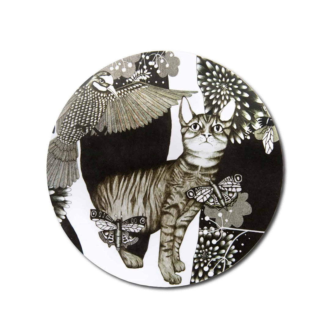 Topfuntersetzer von Nadja Wedin mit schwarz-weißem Motiv einer getigerten Katze, umgeben von einem fliegenden Vogel, Schmetterlingen und floralen Mustern auf weißem Hintergrund.