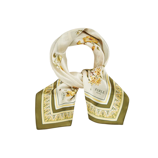 Ein quadratisches Fable England Halstuch aus glänzendem Stoff, locker zu einer Schlaufe gelegt. Sichtbar sind die gelben Narzissen-Illustrationen und der olivgrüne Kontrastrand.