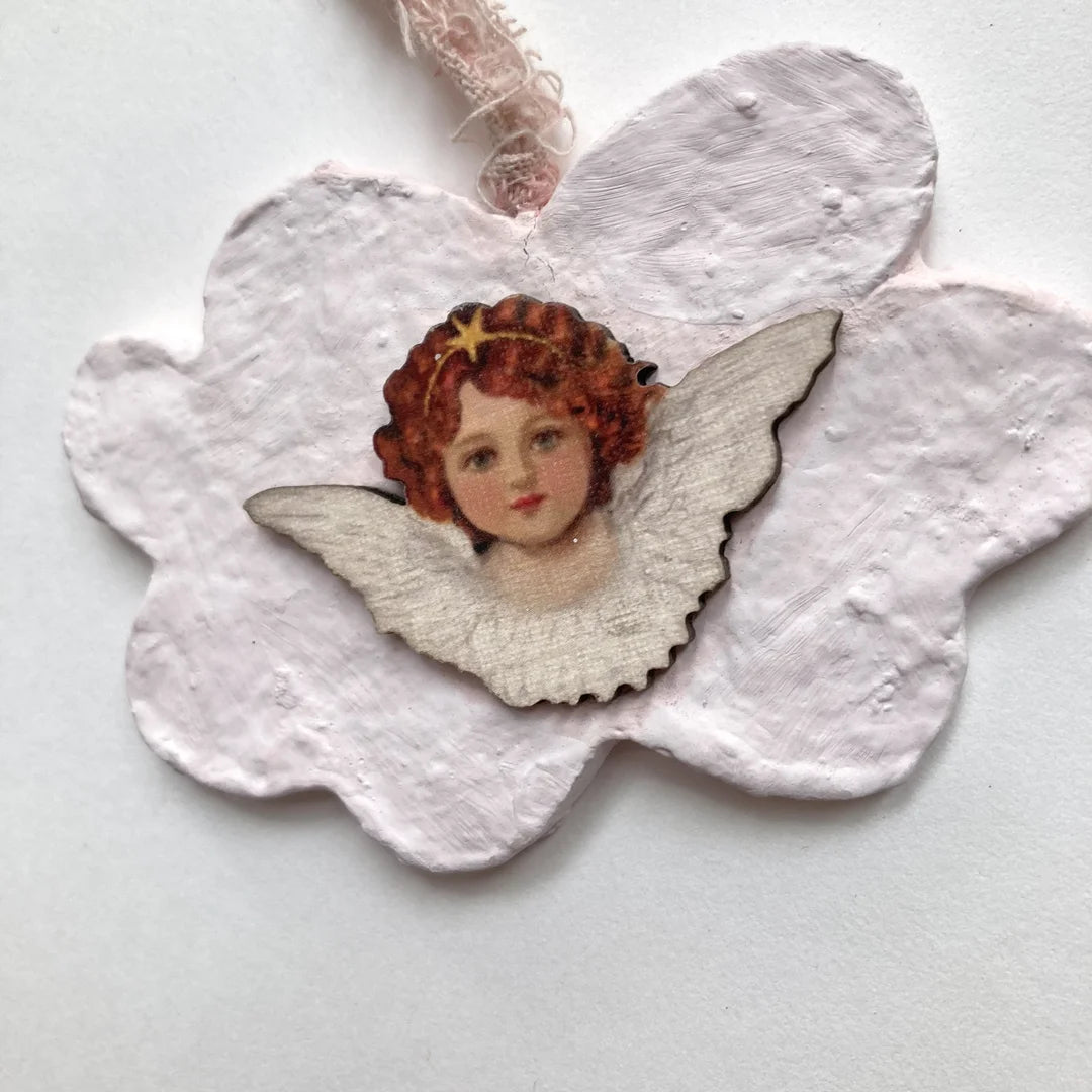 Nahaufnahme des detailreichen Engelsgesichts auf Holz mit funkelndem Sternen-Diadem.