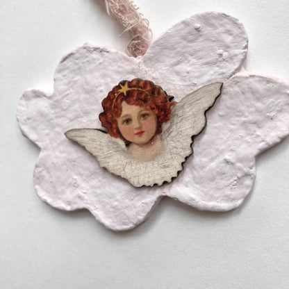 Nahaufnahme des detailreichen Engelsgesichts auf Holz mit funkelndem Sternen-Diadem.