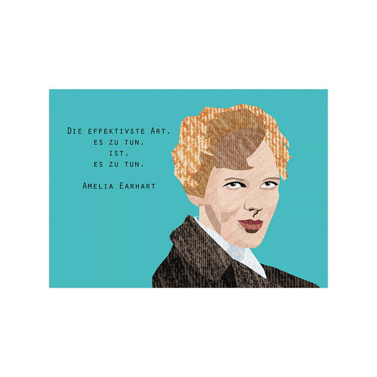 Eine querformatige Postkarte aus strukturierter Pappe. Auf der rechten Seite ist eine stilisierte Illustration von Amelia Earhart mit kurzen, hellen Haaren und einer dunklen Jacke zu sehen. Links daneben steht vor einem kräftigen türkisfarbenen Hintergrund das Zitat: „Die effektivste Art, es zu tun, ist, es zu tun.“ Darunter findet sich der Name „Amelia Earhart“.